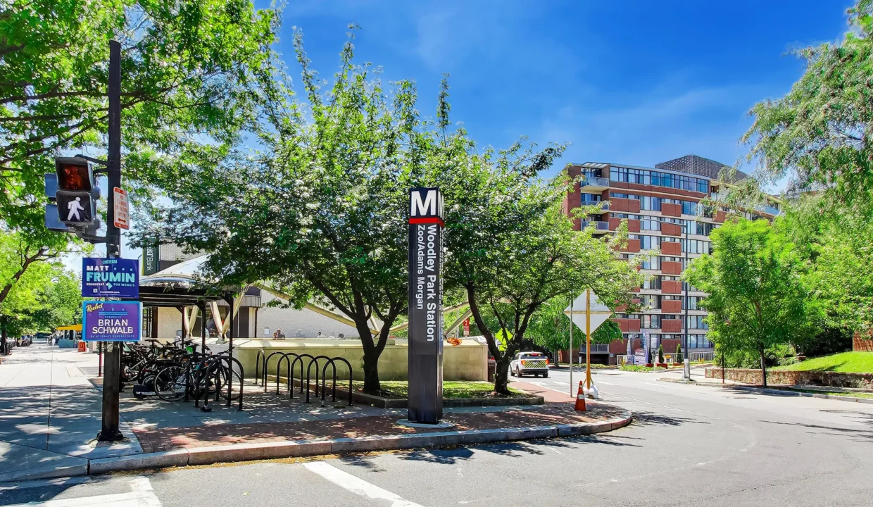 Woodley Park Station Zoo/Adams Morgan Metro pylon sign on a tree-lined corner near 2501 Calvert St NW, Washington, DC