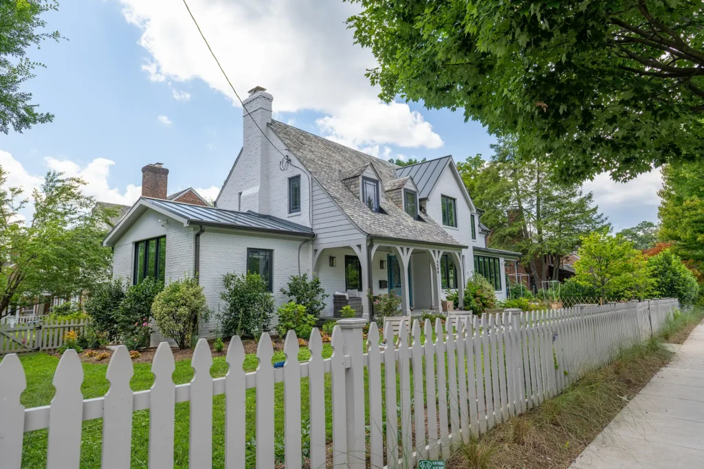 Renovated white-painted farmhouse-style home behind a white picket fence in American University Park, Washington, DC