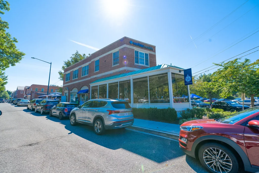 Bluestone Lane cafe with glass-enclosed seating in a brick building near American University Park, Washington, DC