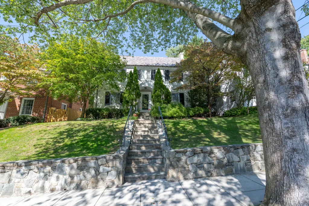 White Colonial reached by stone steps and a fieldstone retaining wall in American University Park, Washington, DC
